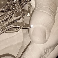 Hände eines Vaters mit seinen beiden jugendlichen Kindern, individuell angefertigtes Glaselement (Nestchen als Teelichthalter).